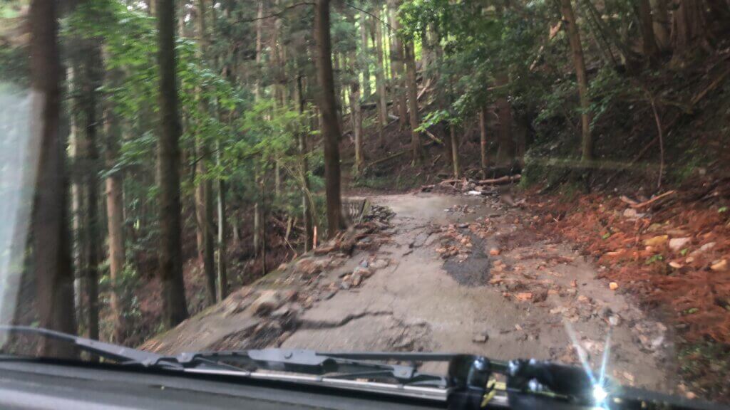 左は崖、舗装も怪しい道を進む